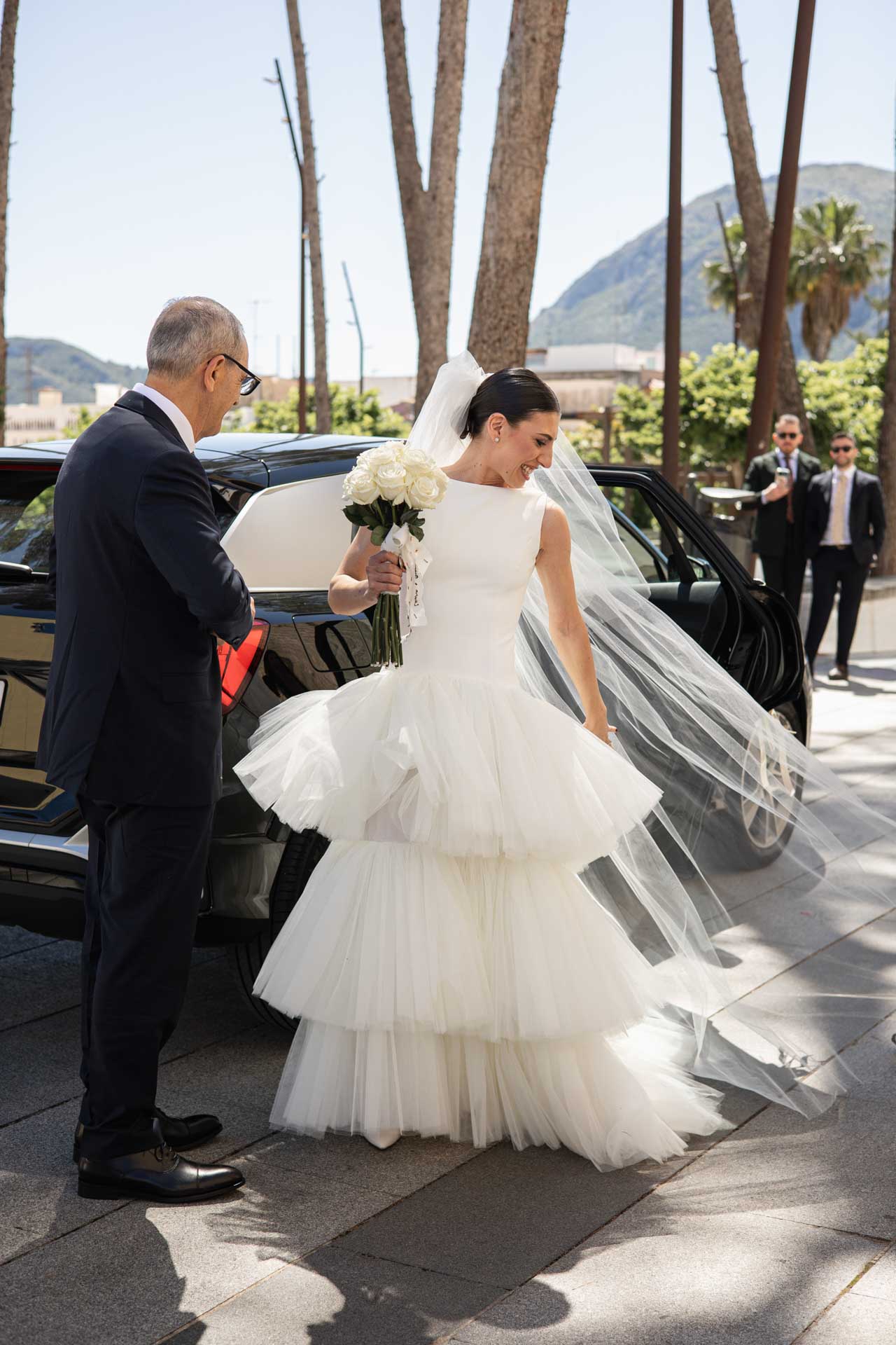 Novia saliendo del coche arreglándose el velo