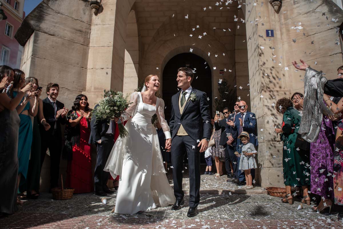 Pareja de novios a la salida de la iglesia en el momento del arroz el día de su boda en Alcoy.