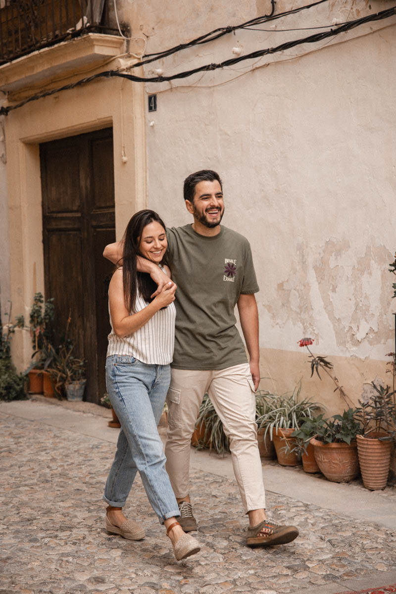 Carlos y Nuria abrazados paseando por las calles de Bocairent durante su sesión preboda