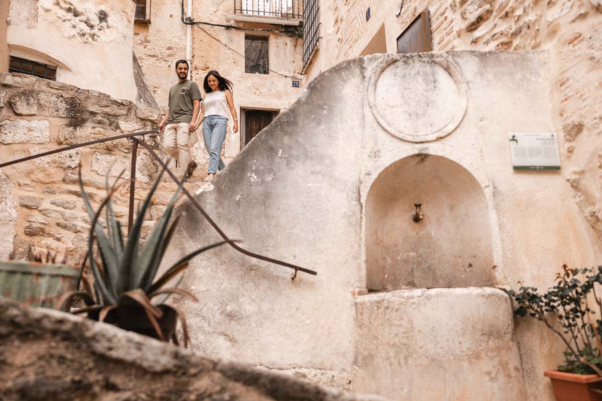 Pareja caminando cogidos de la mano en un rincón de Bocairent durante su preboda.
